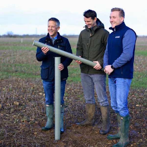 three men holding biodegradable tree shelters at spains hall estate in finchingfield essex